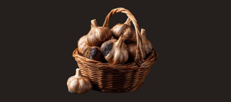 panier en osier , rempli d'ail d'ail noir